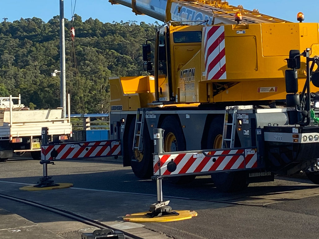 DICA FiberTech 1-inch round composite outrigger crane pad deployed by hand on a job site