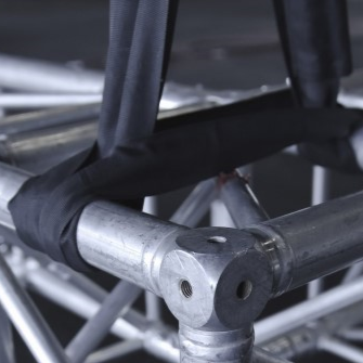Metal truss structure with black straps on a dark background